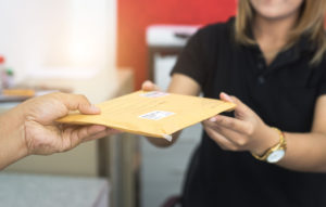 male-hand-send-mail-envelope-to-the-female-of-post-office-before-sending-947998950-5af4d1d1c064710036d60246
